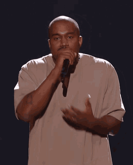 a man singing into a microphone with his mouth open