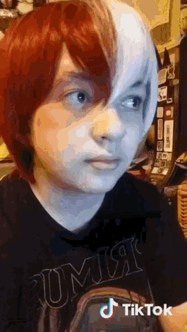 a girl with red and white hair is wearing a t-shirt that says comix on it
