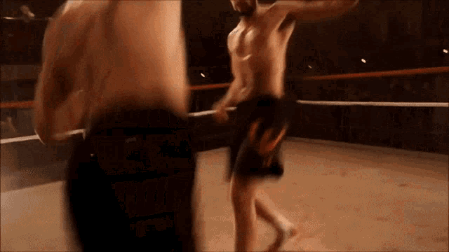 two men are fighting in a boxing ring and one of them has nike shorts on