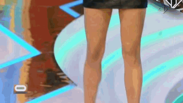 a woman in a short skirt is standing on a stage in front of a sign that says cbs