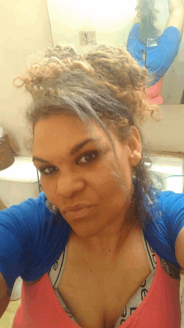 a woman taking a selfie with her hair in a bun