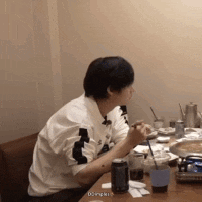 a man sitting at a table with a can of soda and a cup of coffee
