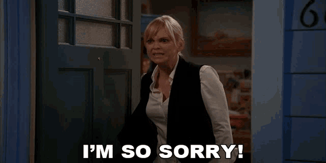 a woman says i 'm so sorry while standing in front of a blue door