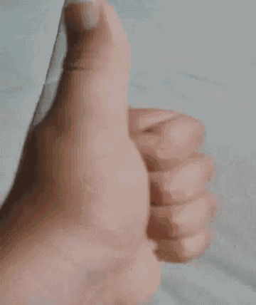 a close up of a person giving a thumbs up