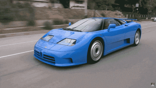 a blue sports car is driving down a street with a sign that says no parking