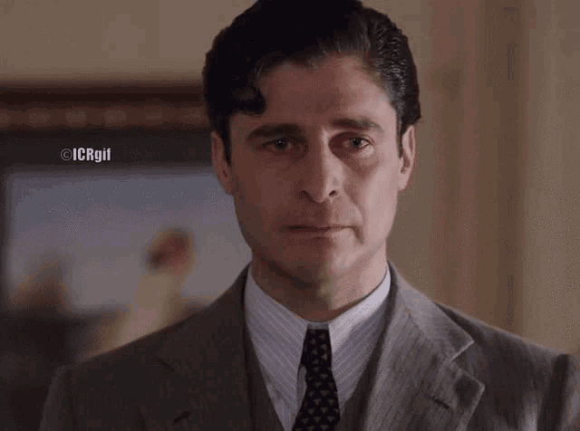 a man in a suit and tie with icrgii written on the bottom