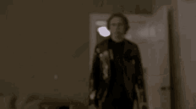 a young man is pointing a gun at the camera .