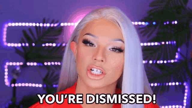 a woman with a red shirt and white hair says you 're dismissed