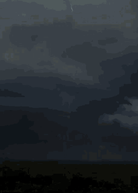 a lightning bolt is hitting a sign that says " fuck you " in the middle of a field .