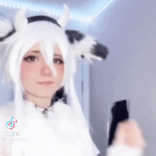 a woman in a cow costume is holding a cell phone .