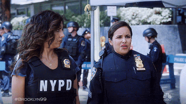 two nypd officers are standing next to each other