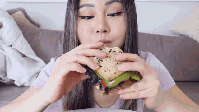 a woman is eating a sandwich with a straw