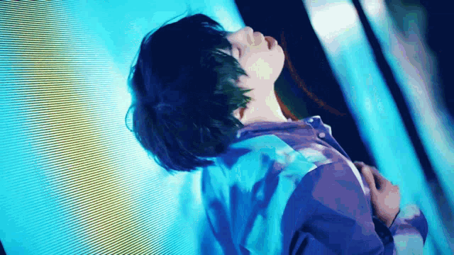 a woman in a purple shirt is looking up at the sky