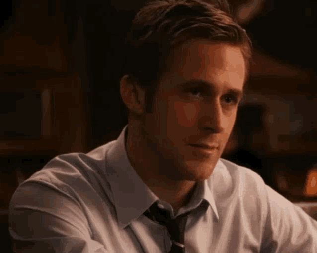 a man in a blue shirt and tie is looking at something
