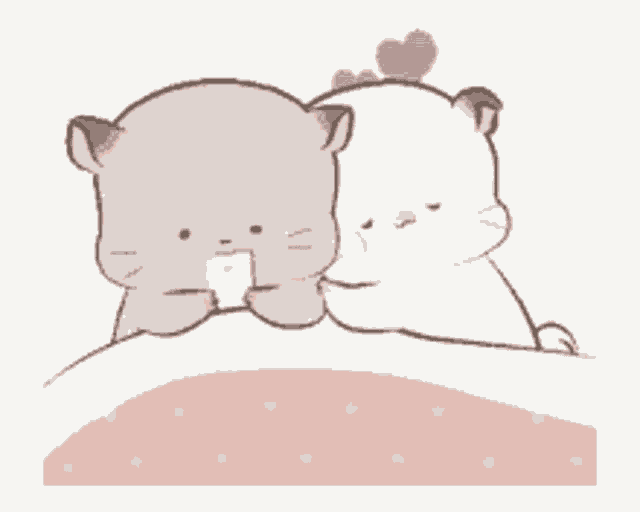 a couple of cats are laying on a bed .