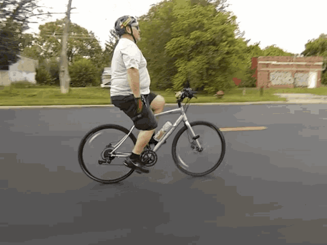a man wearing a helmet is riding a bike on a road
