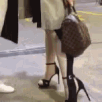 a woman wearing high heels and a backpack is standing next to another woman wearing high heels and a backpack .