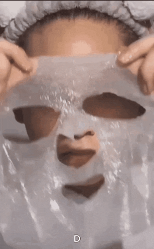 a woman is wearing a plastic mask on her face with a heart cut out of it .