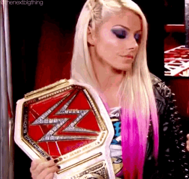 a blonde woman is holding a wrestling championship belt .
