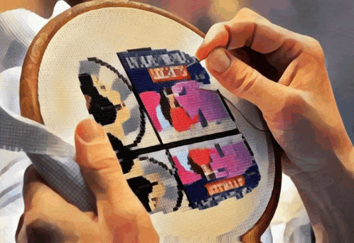 a person is working on a cross stitch with a picture of a man and a woman on it