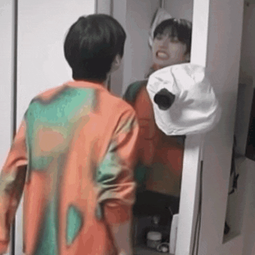 a man is standing in front of a mirror in a closet .