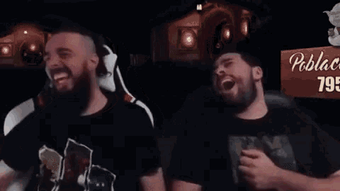 two men are laughing together in front of a sign that says 795 on it .