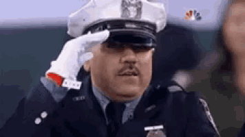 a police officer wearing a hat and gloves salutes .