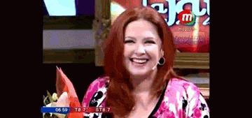 a woman with red hair is smiling in front of a sign that says m & m 's