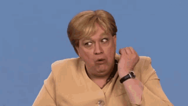 a man dressed as a woman with a watch on his wrist making a funny face