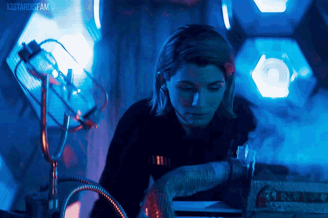 a woman in a dark room with the words 13stardisfam on the bottom right