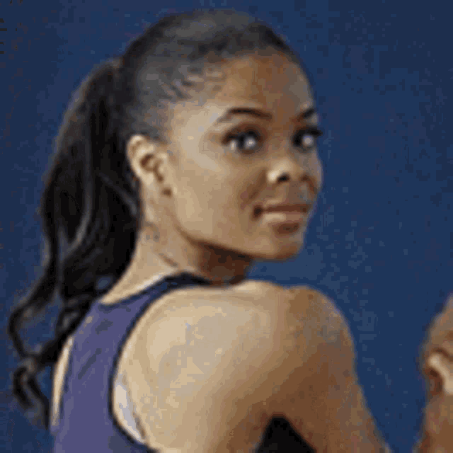 a woman is wearing a purple tank top and a black tank top .