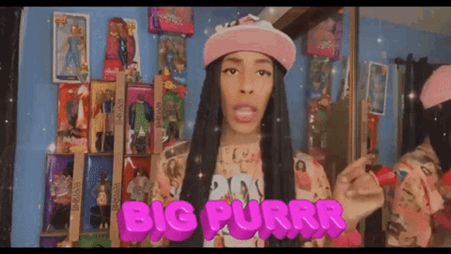 a girl in a pink hat is standing in front of a wall of dolls and says big purrr