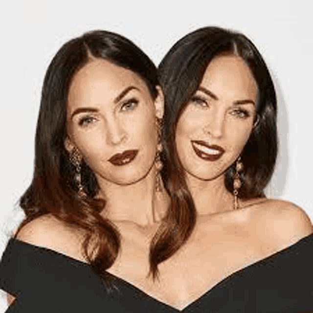 two women are standing next to each other and smiling for the camera .