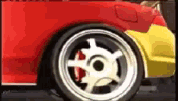 a close up of a red car with a yellow car in the background