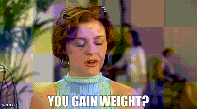 a woman in a blue sweater is talking to someone and asking if they gain weight .