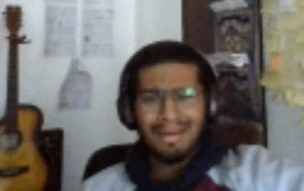 a man wearing headphones is smiling in front of a guitar .
