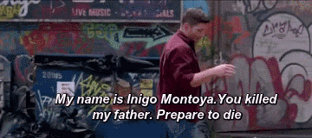 a man is walking in front of a wall with graffiti on it and says my name is inigo montoya you killed