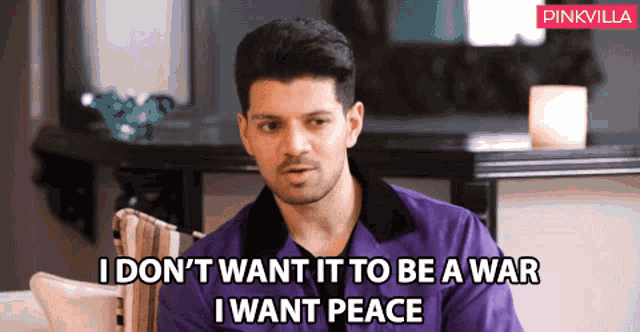 a man in a purple shirt is saying " i don t want it to be a war i want peace "