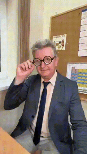a man in a suit and tie is wearing glasses