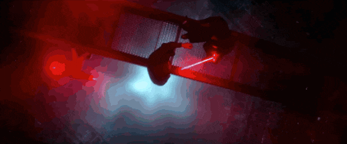 a person is holding a light saber while another person is walking across a bridge