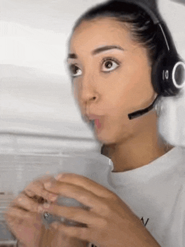 a woman wearing headphones and a microphone is holding a cup of coffee .