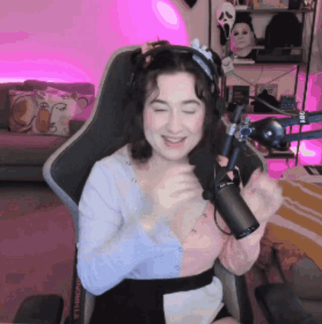 a woman wearing headphones is sitting in a chair with a rode microphone