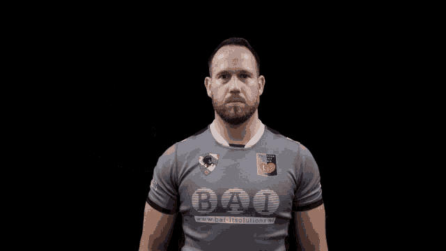 a man wearing a shirt that says bao is flexing his arm