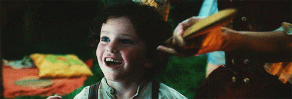 a little boy is smiling and looking up at something