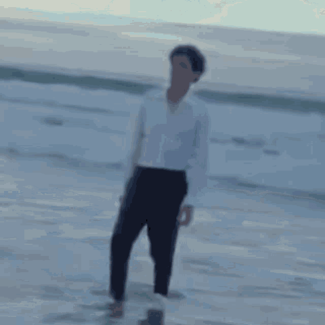a blurry picture of a person standing on a beach .