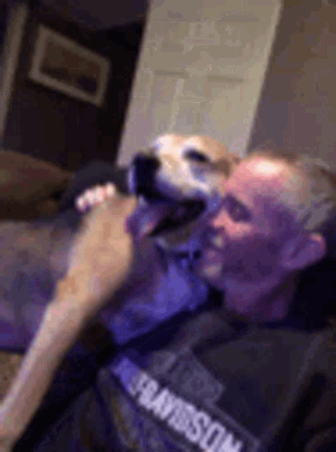 a man is sitting on a couch with a dog .