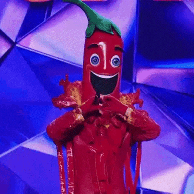 a person dressed as a red pepper on a stage .