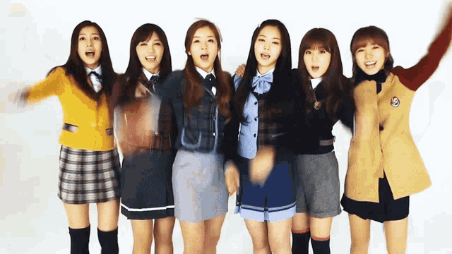 a group of young girls in school uniforms are standing together