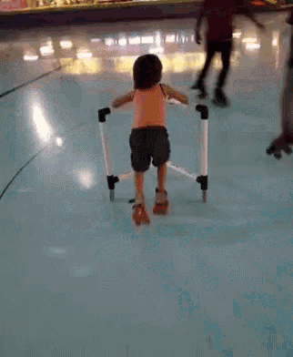 a little girl wearing roller skates is walking on a rink