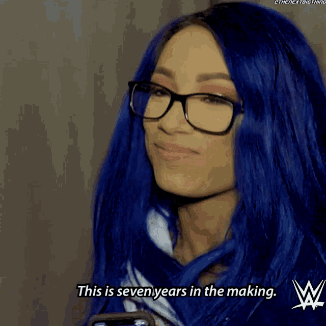 a woman with blue hair is wearing glasses and says this is seven years in the making